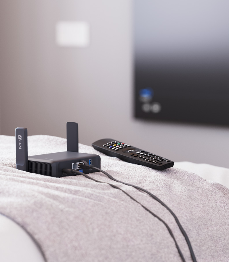 GL.iNet Slate 7 (GL-BE3600) 12 Slate 7 router on bed behind remote tv controller
