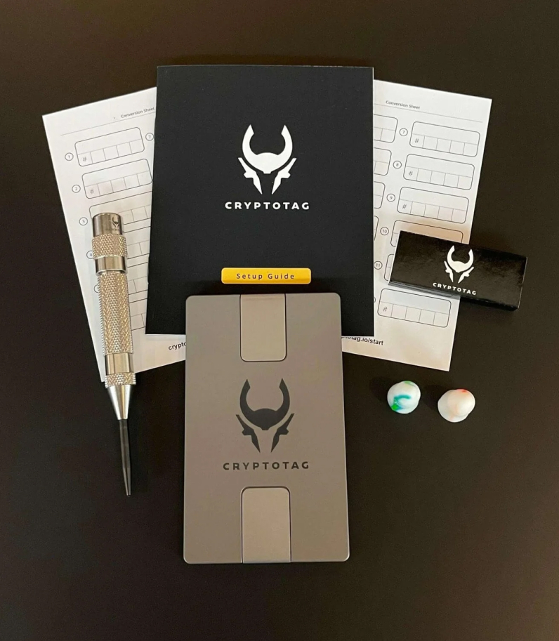 CryptoTag Zeus 13 Cryptotag Zeus on desk with kerner earplugs seedphrase cards and user manual