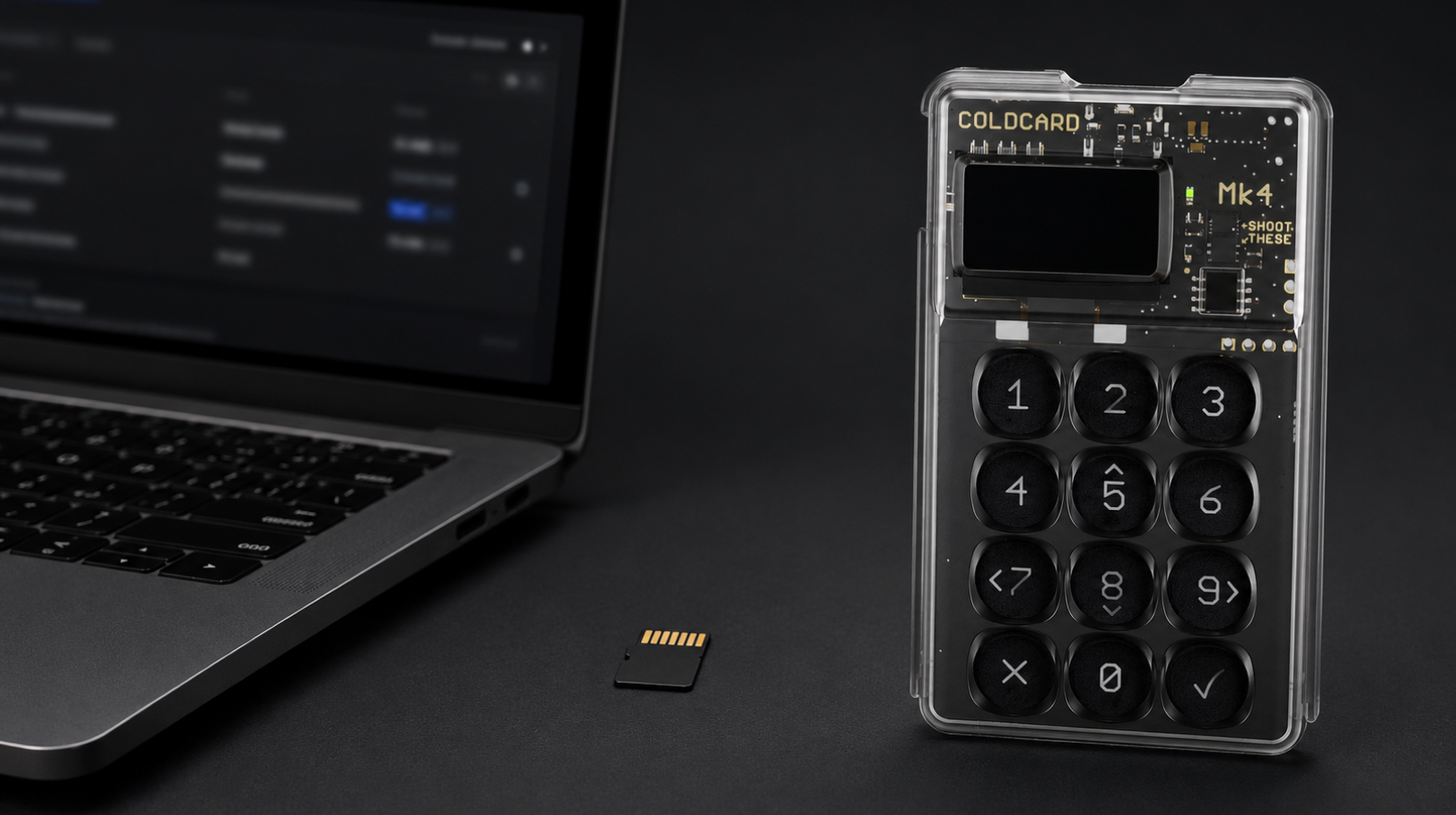 Coldcard MK4 On Table With MicroSD Card Behind Laptop